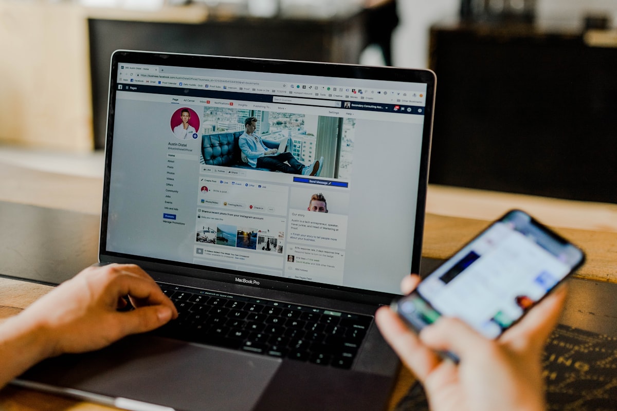 Marketing professional managing social media campaigns on desktop and mobile devices simultaneously